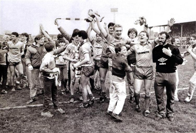 Team and fans celebrate on pitch